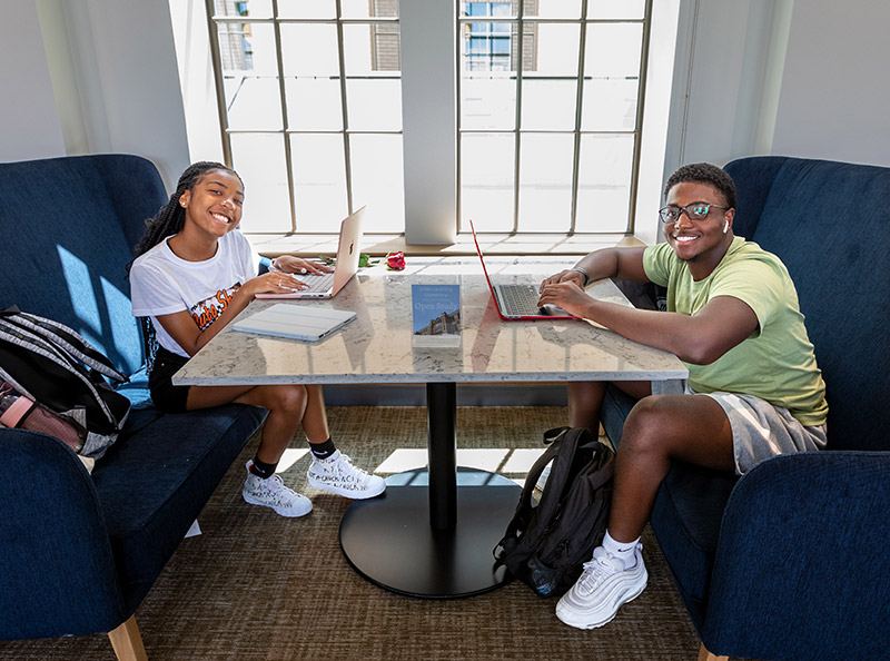 Students sitting at a table with their laptops